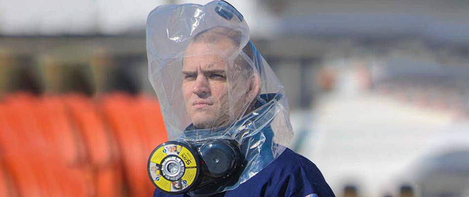 Product demonstration photo of someone wearing an ILC Dover SCape CO/CBRN 30 Escape Respirator.